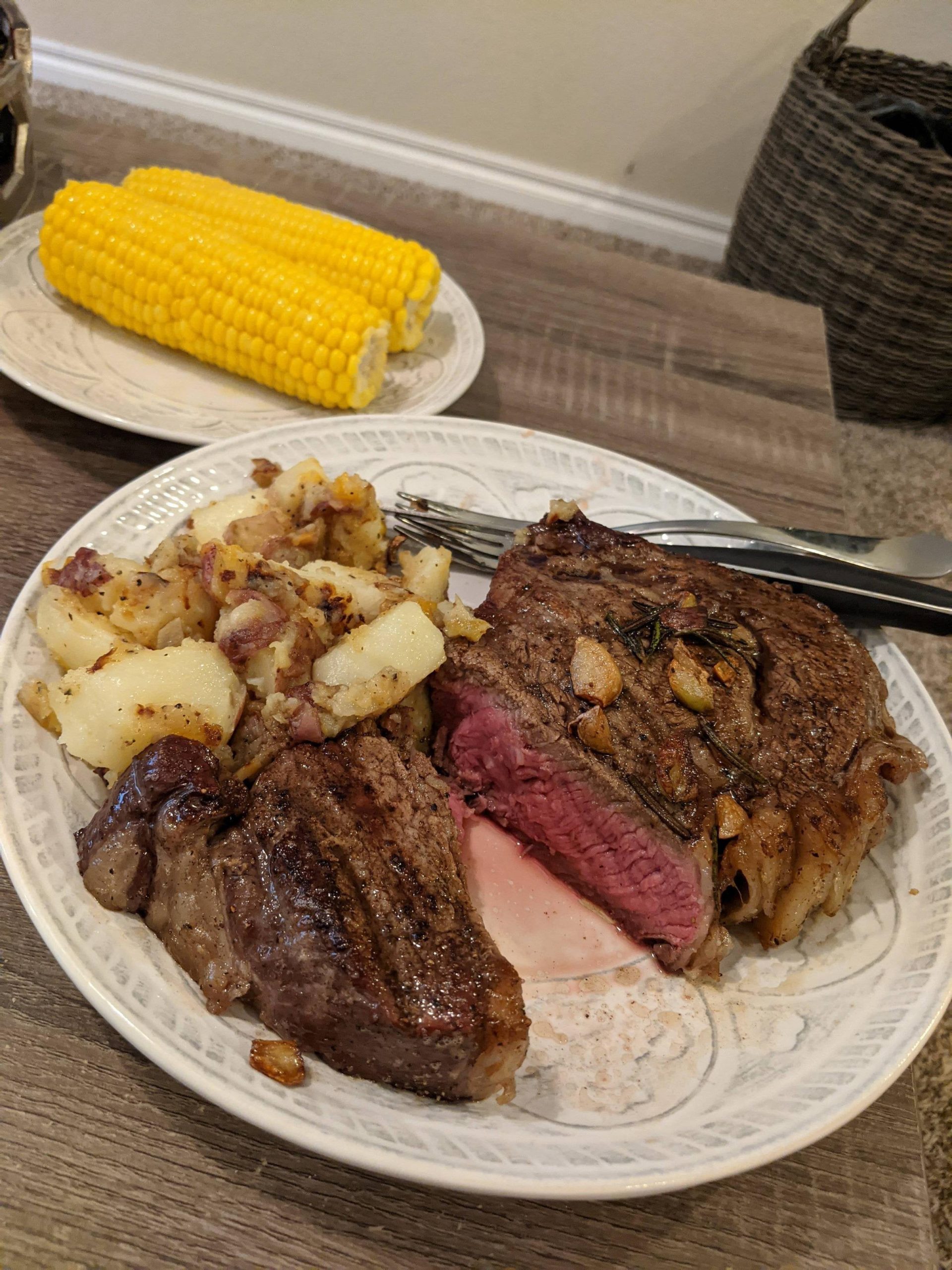 2 Inch Ribeye with German fried potatoes and corn on the cob (reverse