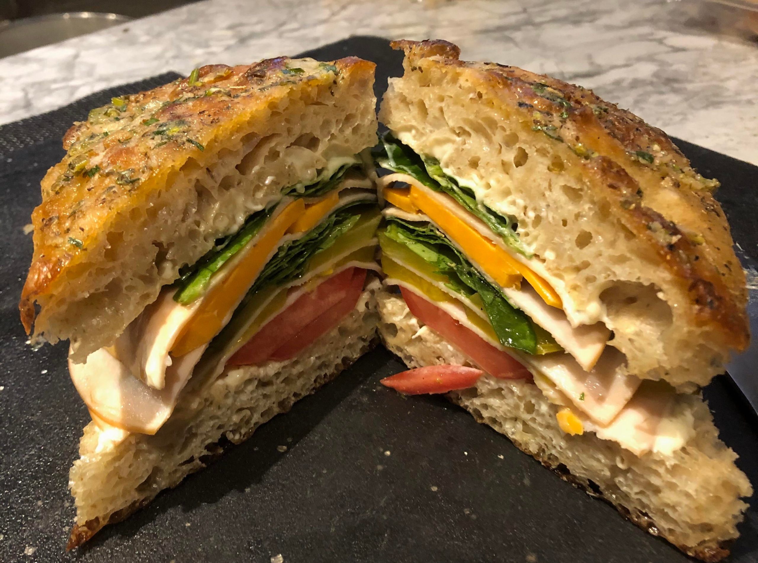 Focaccia, turkey, garlic mayo, dressed greens, local tomatos, old