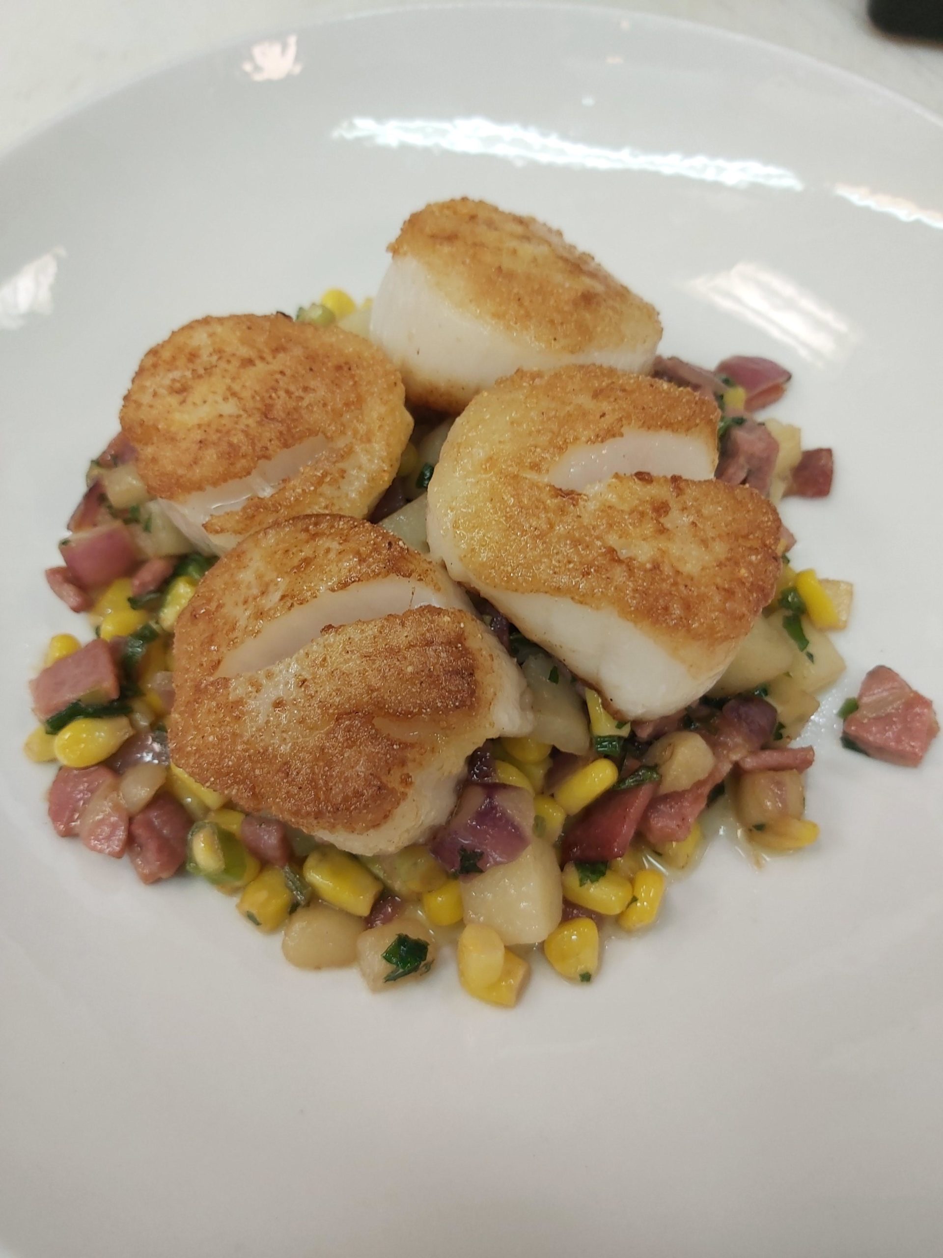Cornmealcrusted scallops, with a hash of sweet corn, country ham and