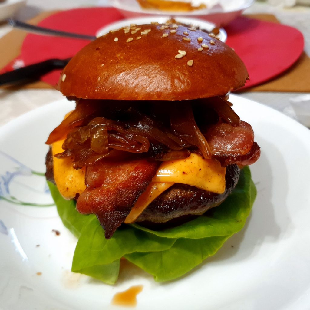 Homemade Burger with Bacon, Lettuce and Tomato, topped with Caramelized Onions