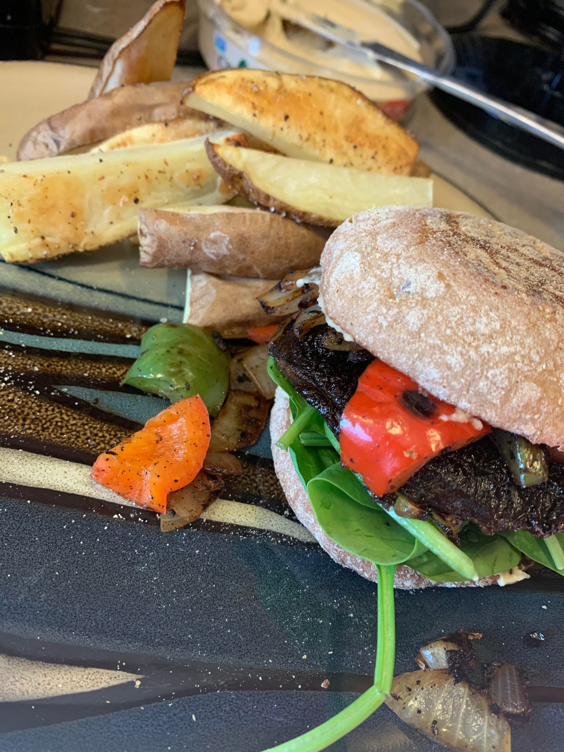 Portobello mushroom cap burger w/ hummus, spinach, grilled tofu slice, onions and bell peppers