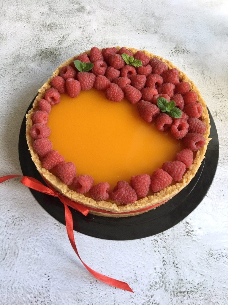 Mango/passion fruit cheesecake, garnished with raspberries.