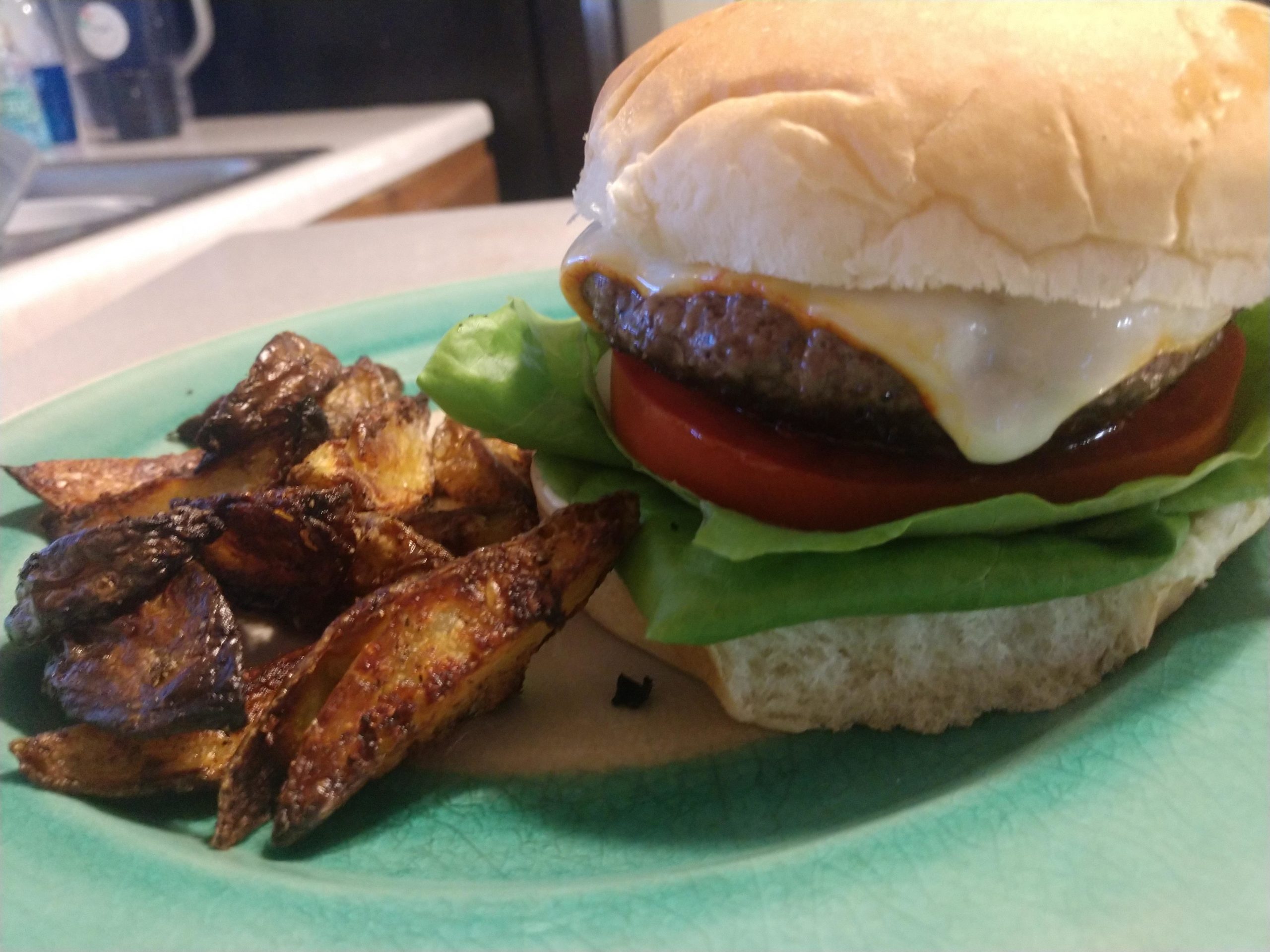 Pan seared burger with a side of patato wedgies Dining and Cooking