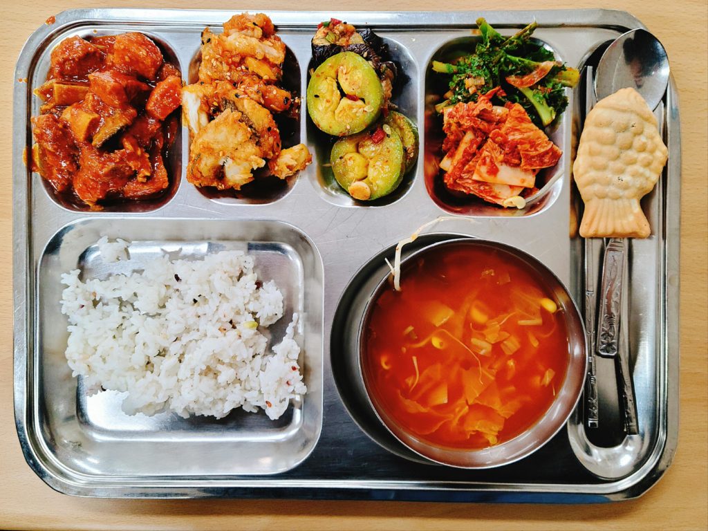 My Korean School lunch of Braised Spicy Pork, Fried Sweet and Spicy Cutlass Fish, and Kimchi Beansprout Soup with Assorted Banchan