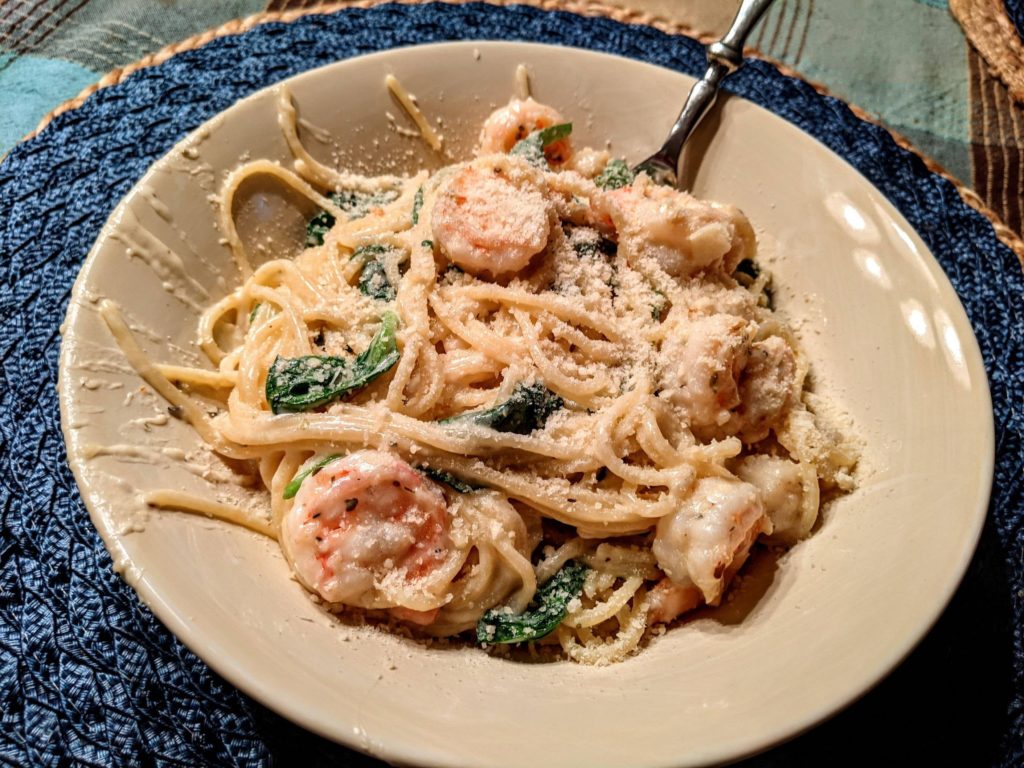 Shrimp and bay scallop pasta in a garlic and white wine cream sauce with wilted spinach