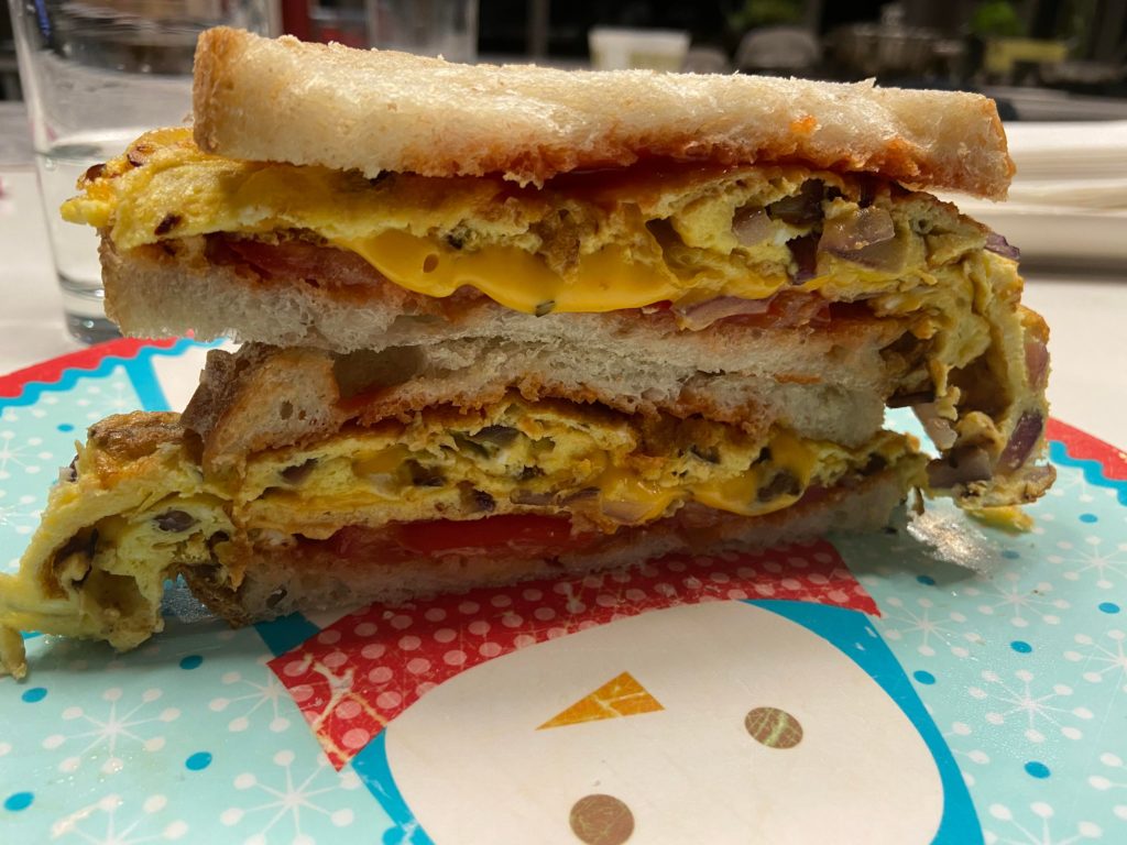 Egg sandwich for dinner (onion, tomato, cheese, ketchup & hot sauce)