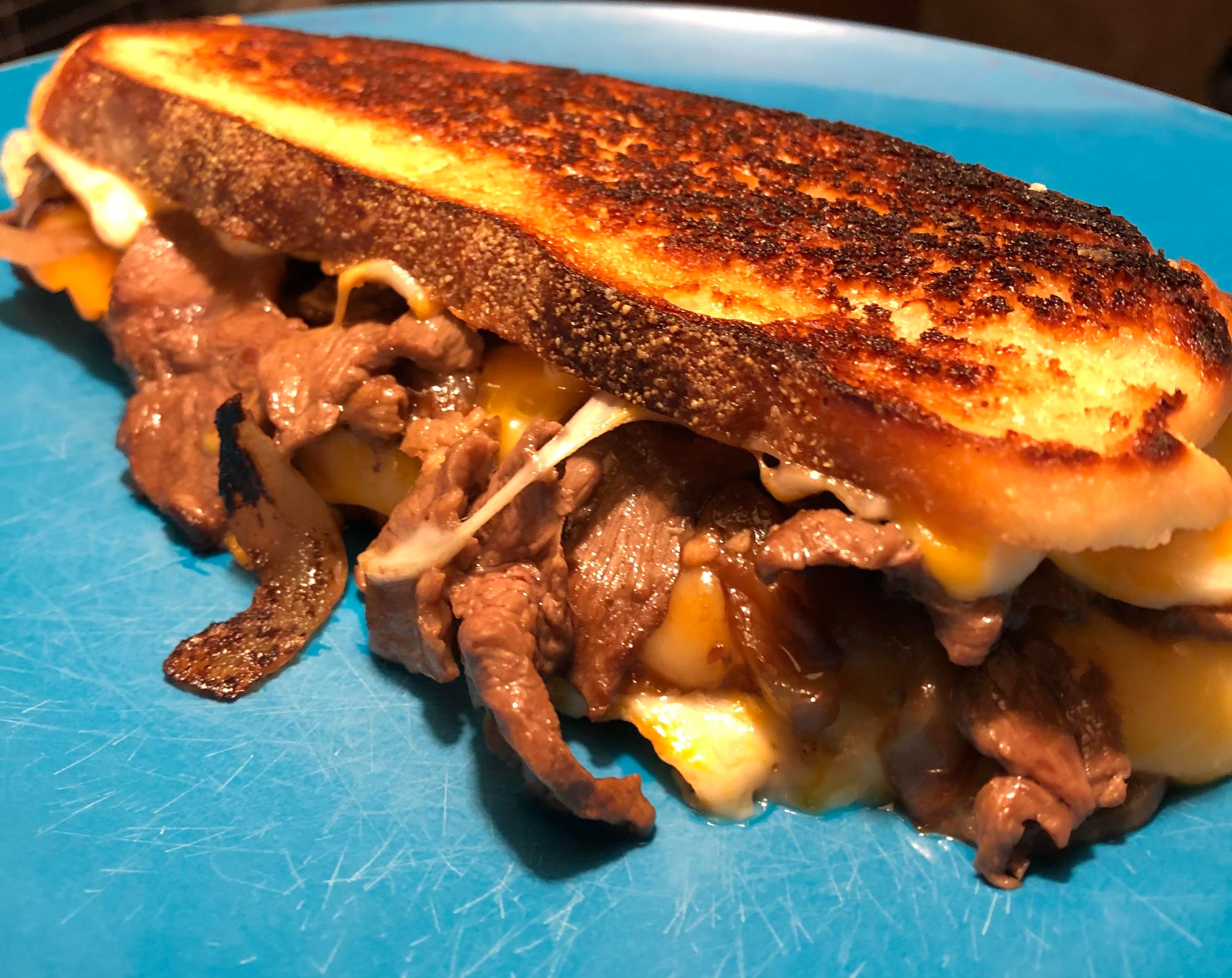 Beef short rib sandwich with onions, garlic, and cheese on homemade