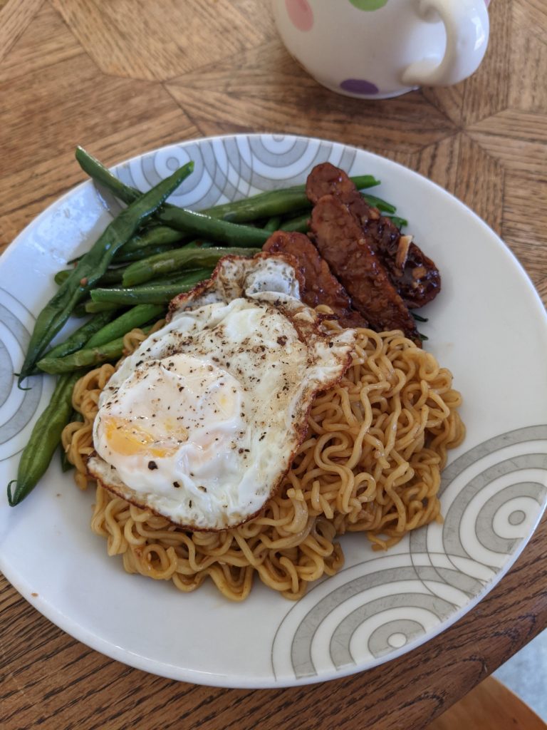 Indomie noodles, leftover green beans and saucy tempeh, topped with a fried egg to make it breakfast
