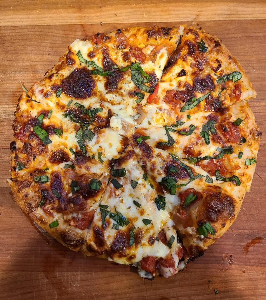 Four cheese pan pizza with fresh basil