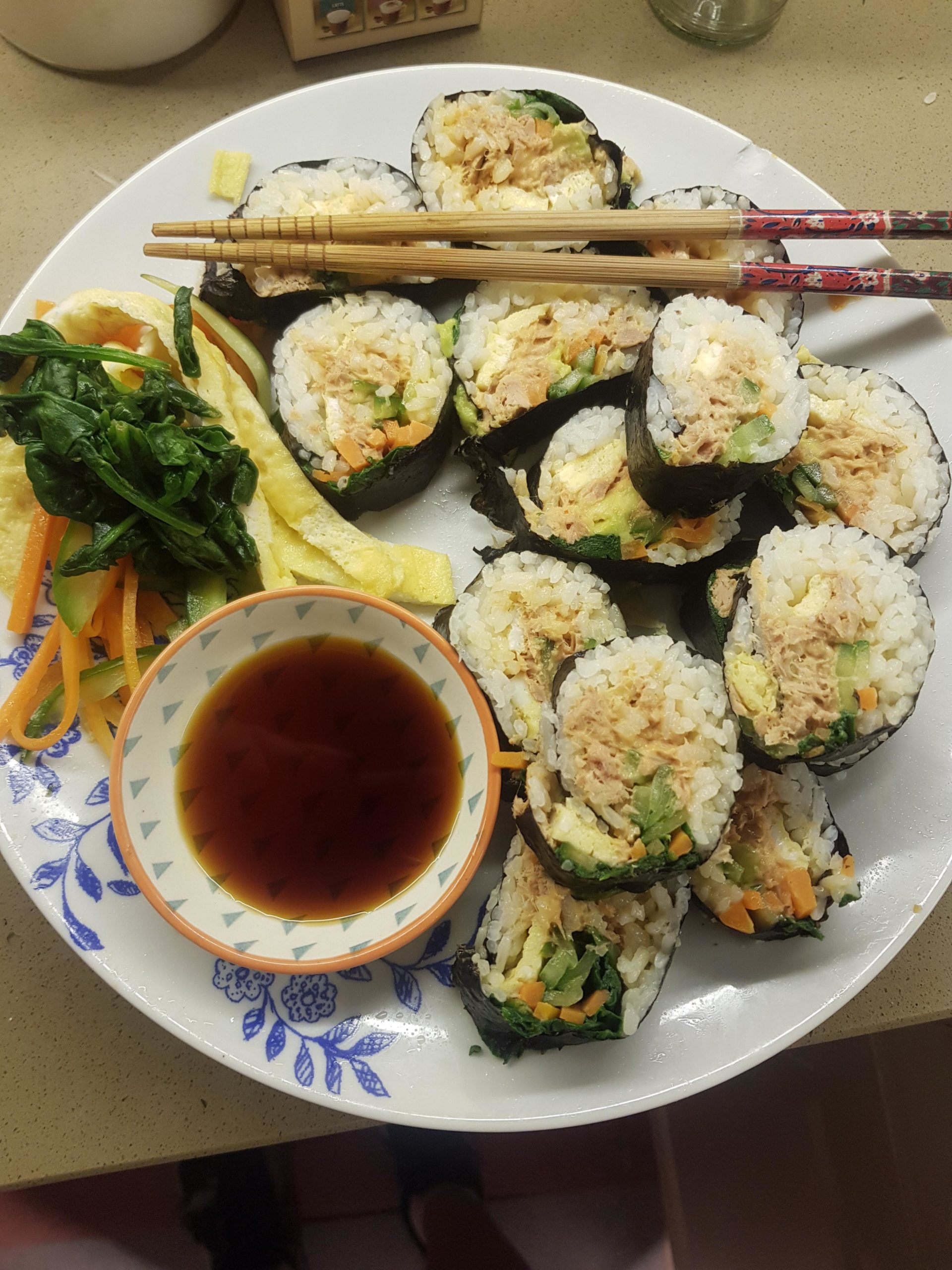 Spicy tuna kimbap with avocado, pickled cucumber, carrot, spinach and