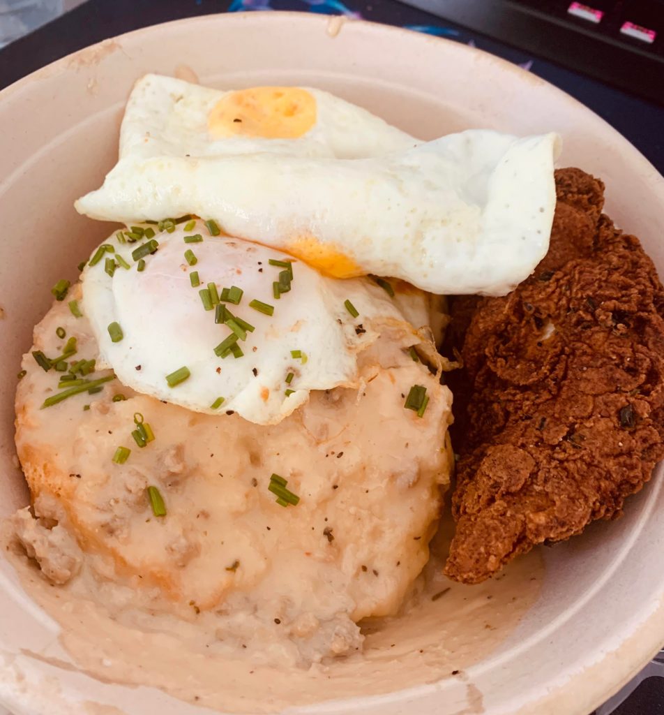 Biscuits and gravy with fried chicken and two over easy eggs