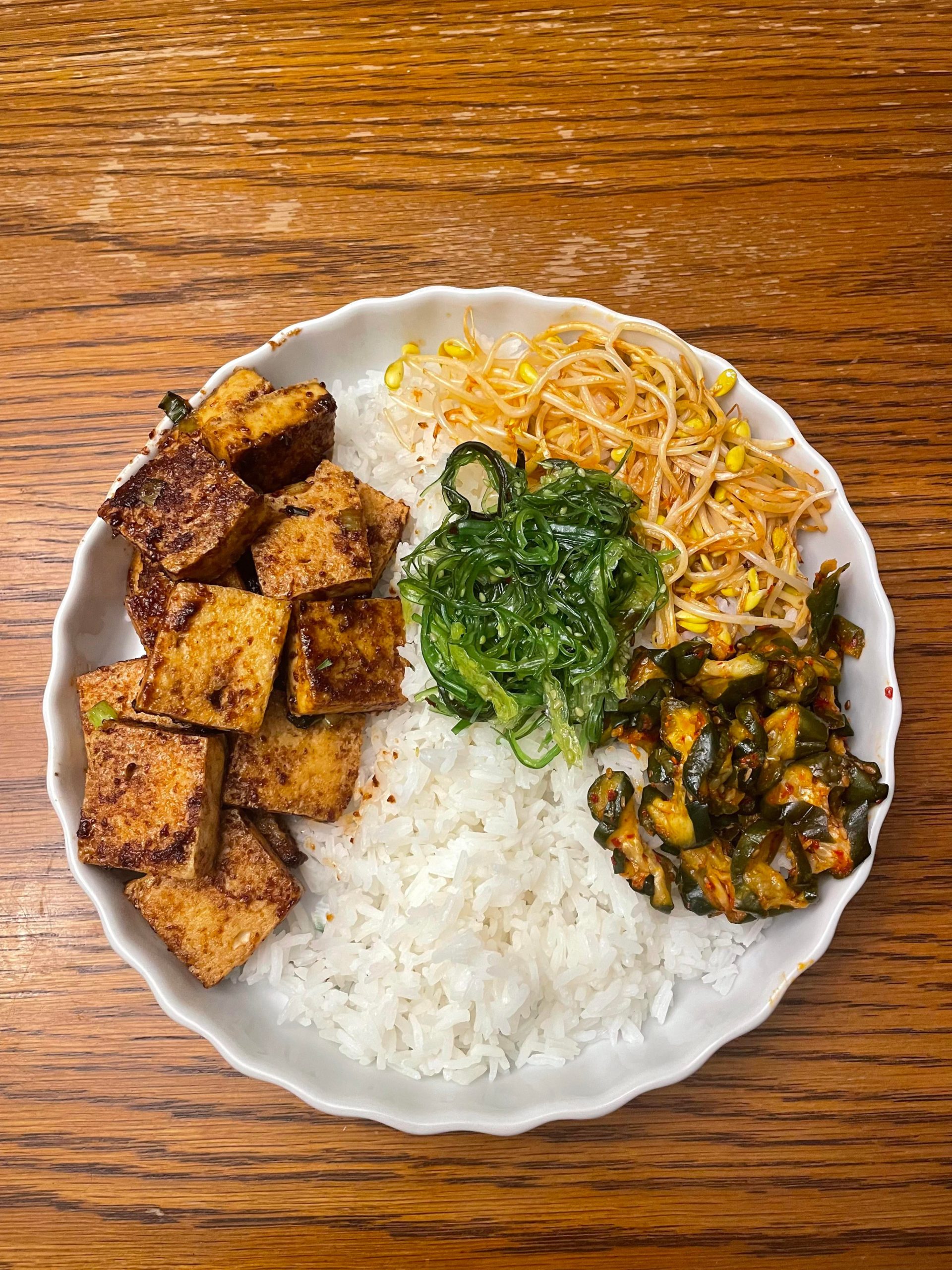 Tofu bulgogi with bean sprouts, cucumber kimchi, and seaweed salad