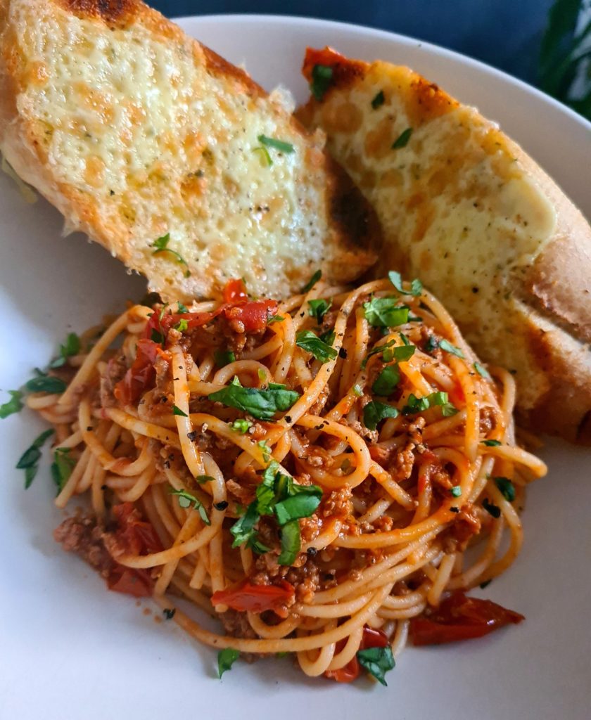 Spaghetti bolognese with cheesy garlic bread.