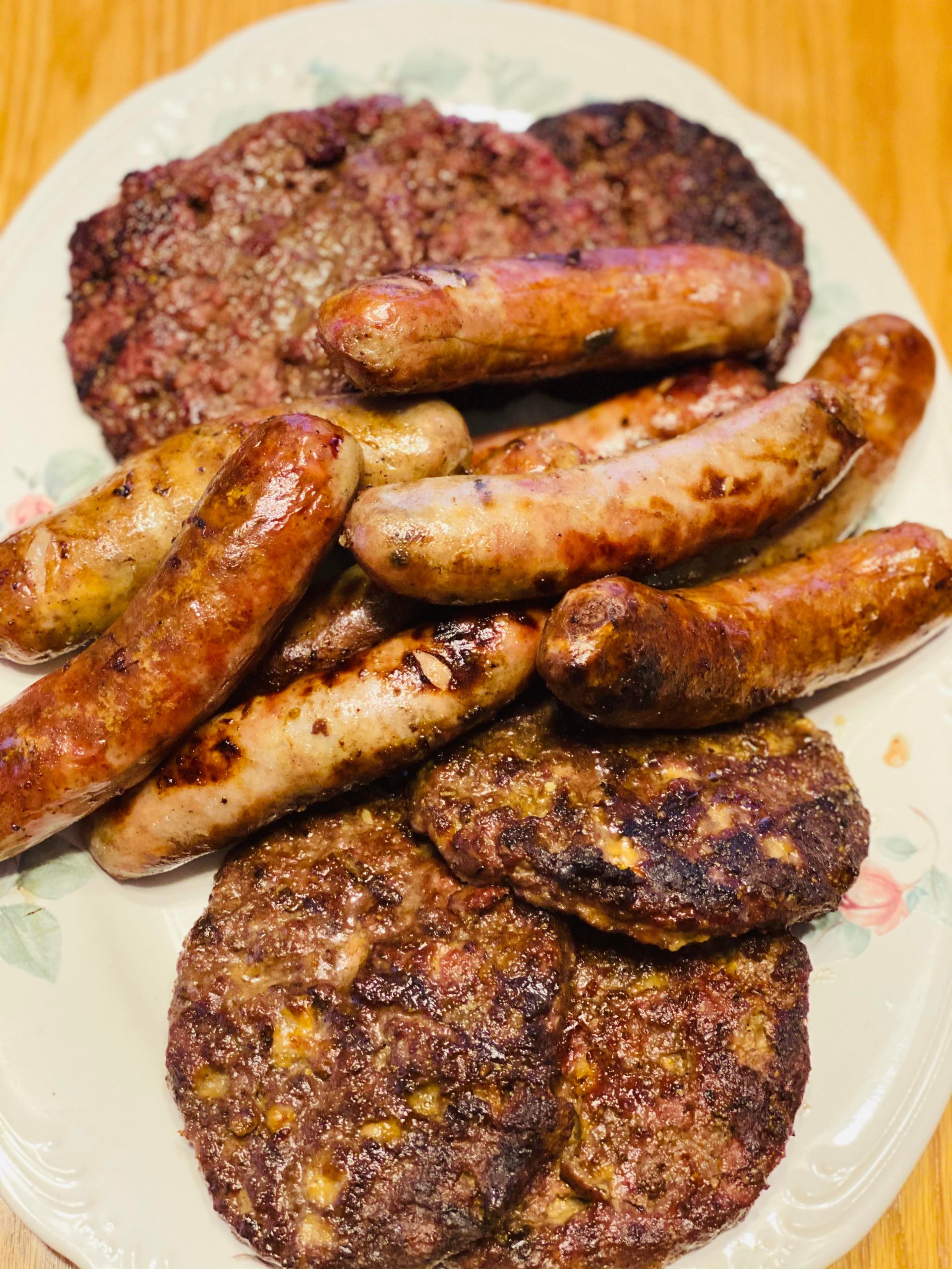 Burgers, cheddar brats, regular brats, and bacon cheddar brats cooked