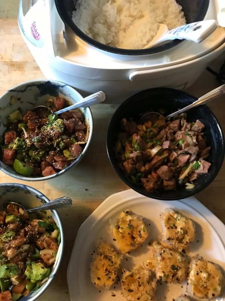 Steamed rice, Filipino kilawin with beef, grilled California rolls, salmon poke, and tuna poke! Not pictured: seaweed salad and unagi.