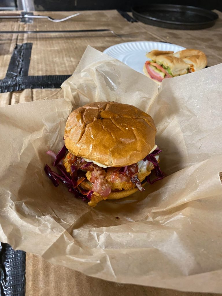 Fried haddock sandwich pickled red cabbage bacon cheese and tartar.