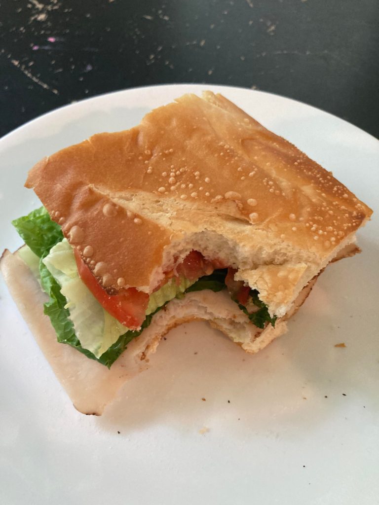 Turkey, lettuce, tomato, mayo, Italian dressing on a toasted baguette.