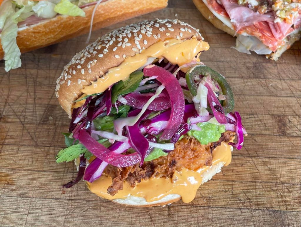 Fried chicken breast, Valentina aioli, avocado, and spicy pickled onion slaw