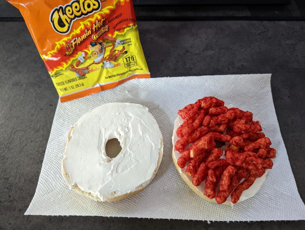 Cream cheese and Flamin' Hot Cheetos on a plain bagel.