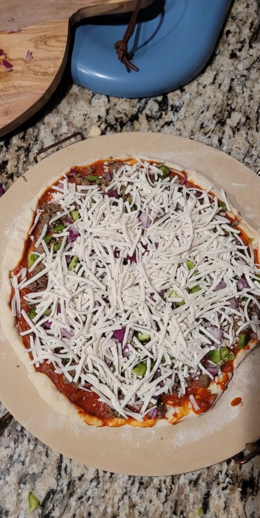 Homemade vegan pizza, with impossible sausage, green peppers, and red onion