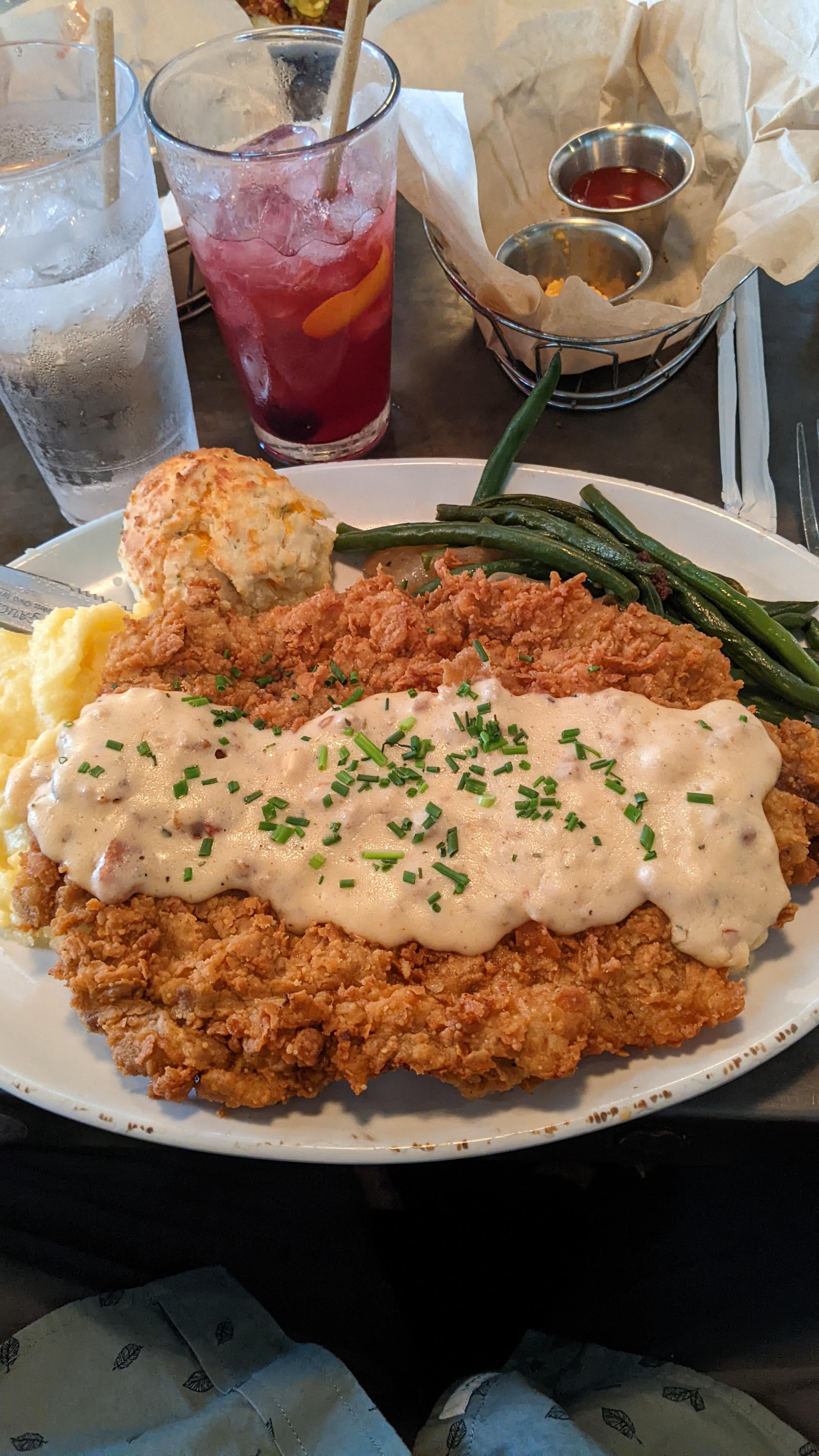 A slab of country fried steak, mashed potatoes, green beans, and a