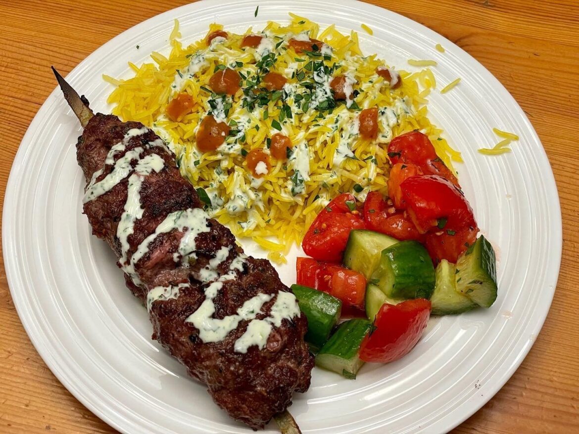 Grilled beef kofta kebab, turmeric rice, and cucumber tomato salad