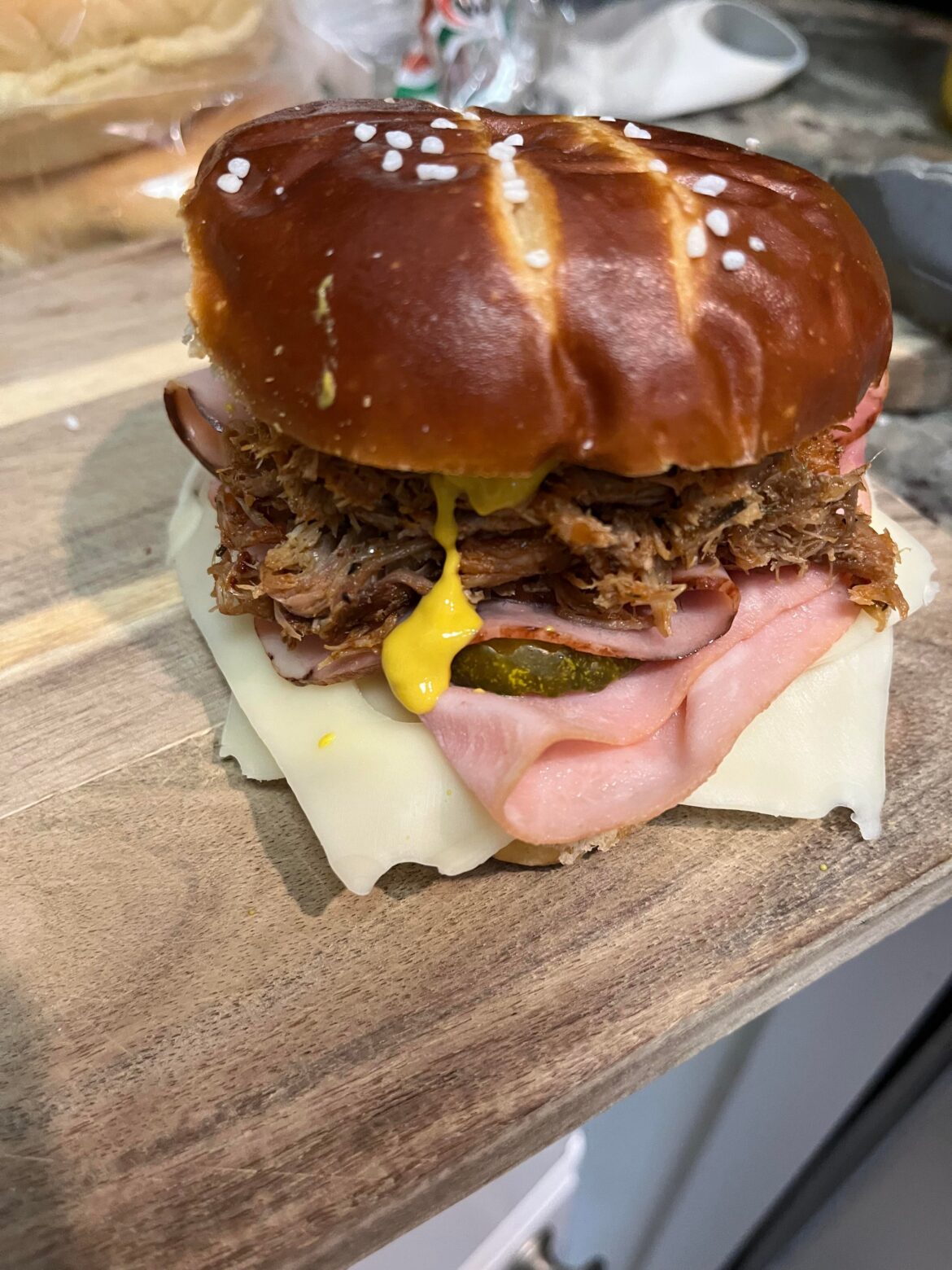 Homemade Cuban sandwich on pretzel roll