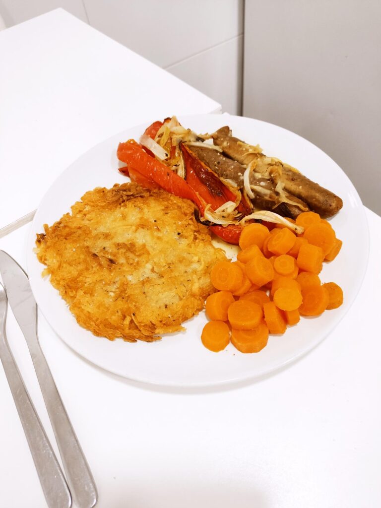 Vegan tofu sausages with roasted peppers and onions, potato rösti, lemon and coriander carrots and Dijon mustard gravy