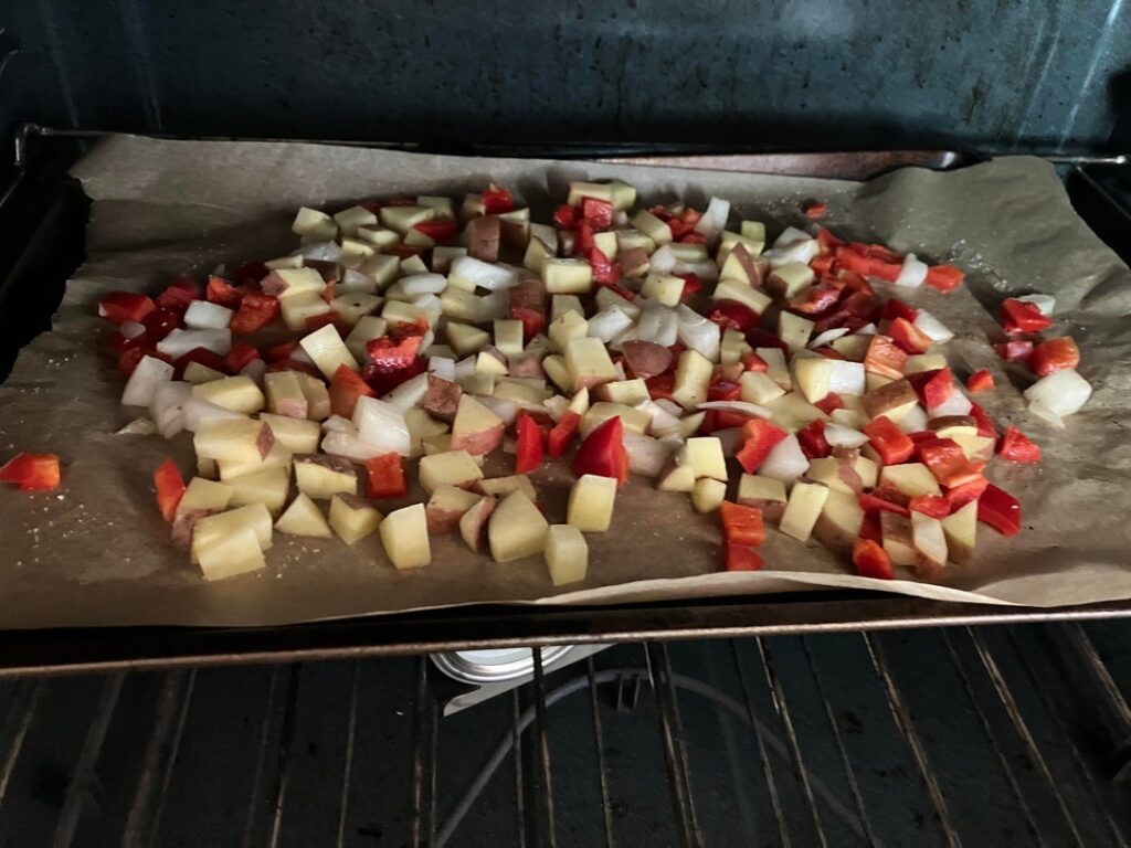 Mini breakfast prep of potatoes with onion & bell pepper, sliced sausage, & scrambled eggs.