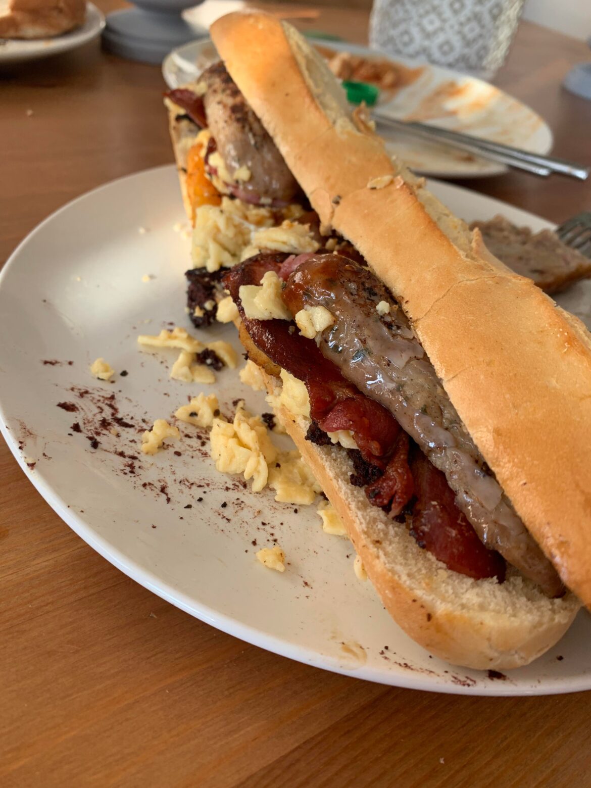 Breakfast baguette. Bacon, sausage, scrambled egg, hash brown and black pudding
