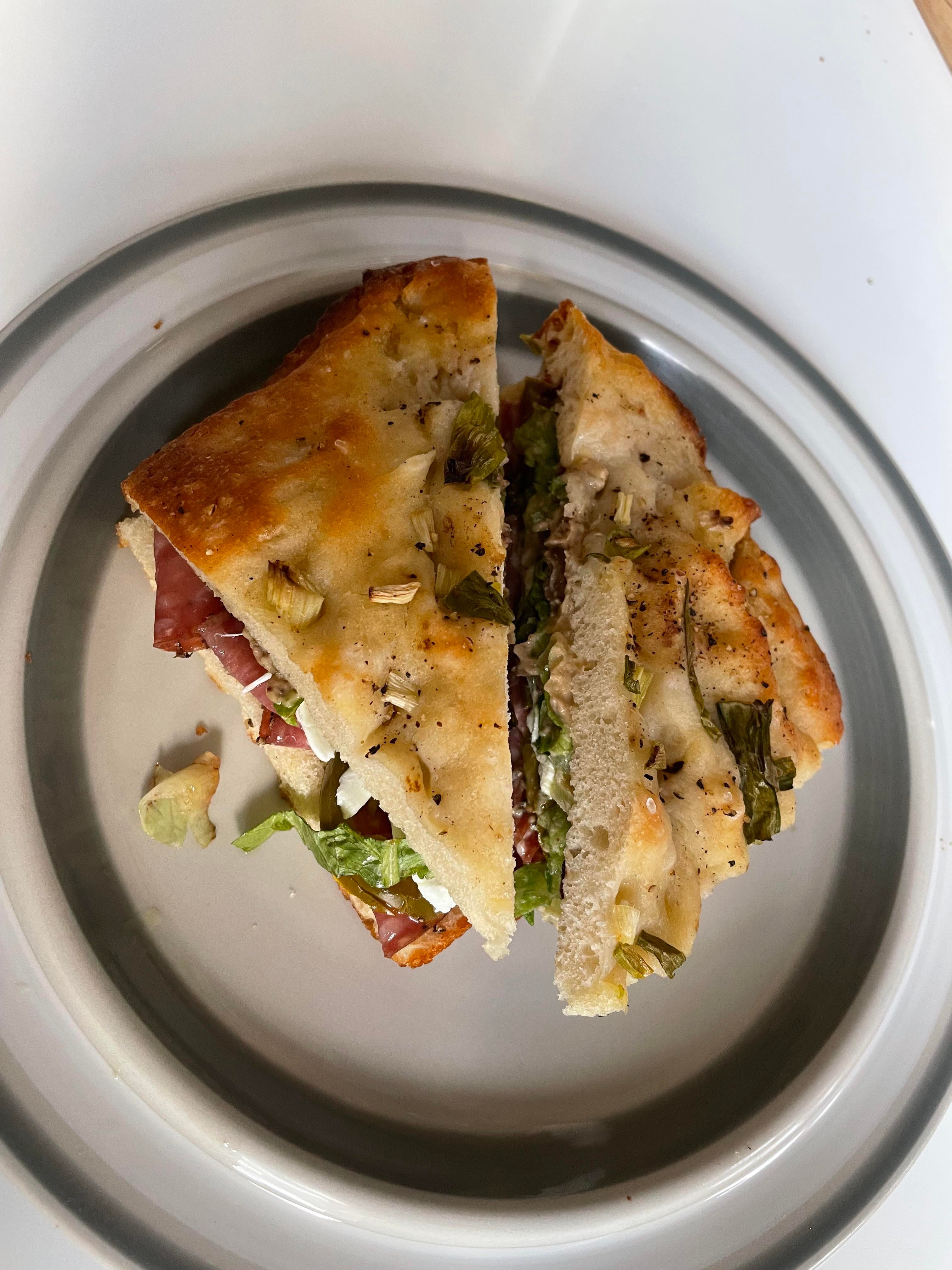 Salami, jalapeños, oaxaca cheese, shredduce, and olive hummus on home