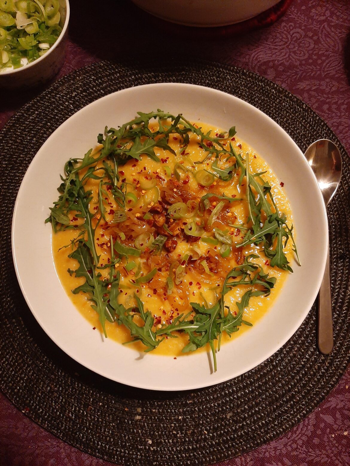 Celery root and turnip soup, topped with mushrooms, caramelised onions, spring onions, rocket salad and chili flakes