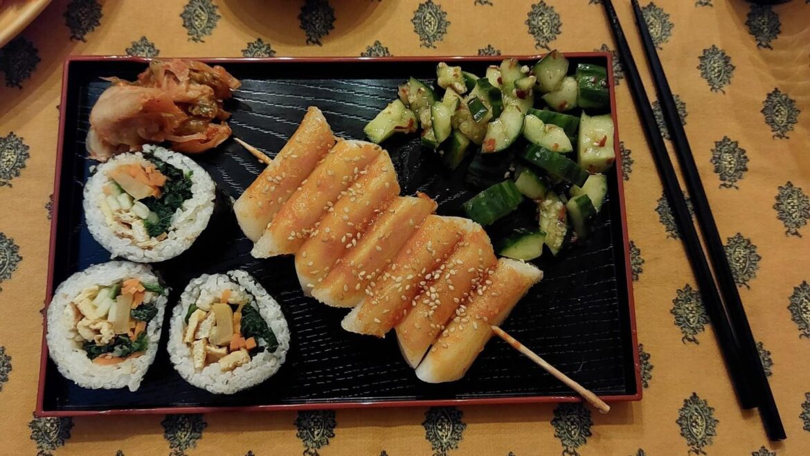 Homemade gimbap, tteok-kkochi and cucumber salad, served with some kimchi