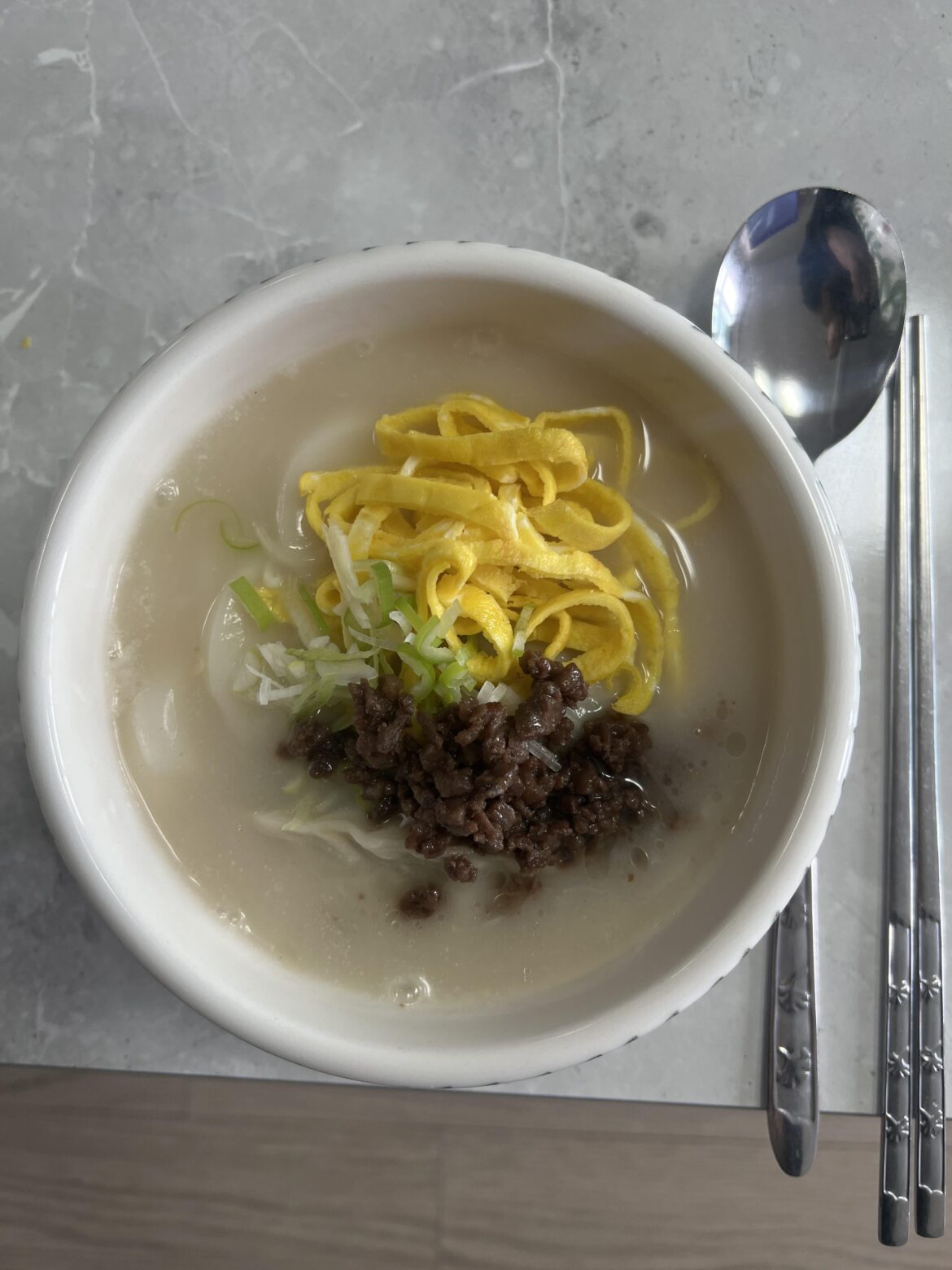 Tteok-guk ( Soup with beef broth and slices of rice cake, eggs, etc.)