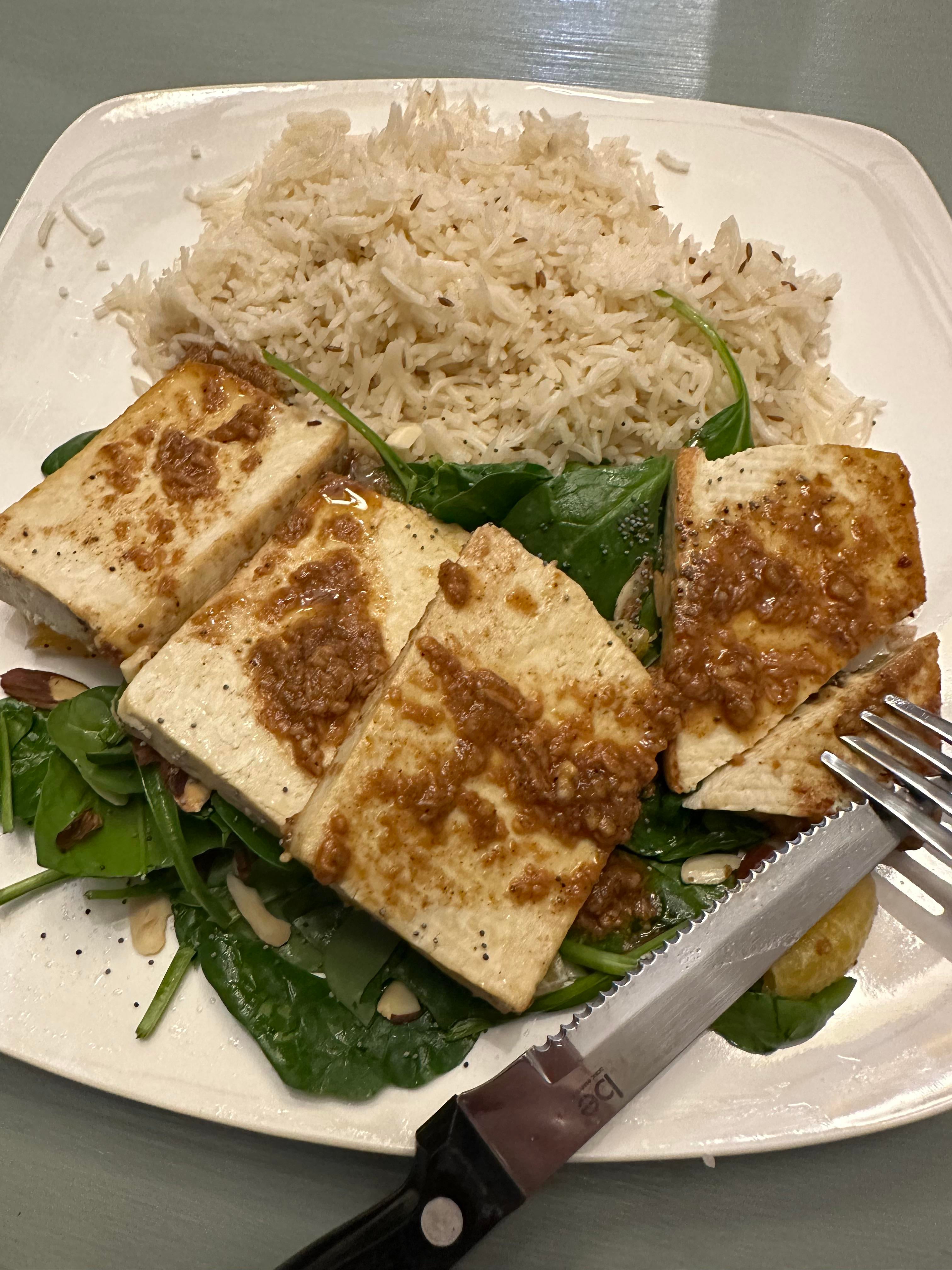 Marinated tofu steaks over spinach and nuts with basmati rice. Dining and Cooking