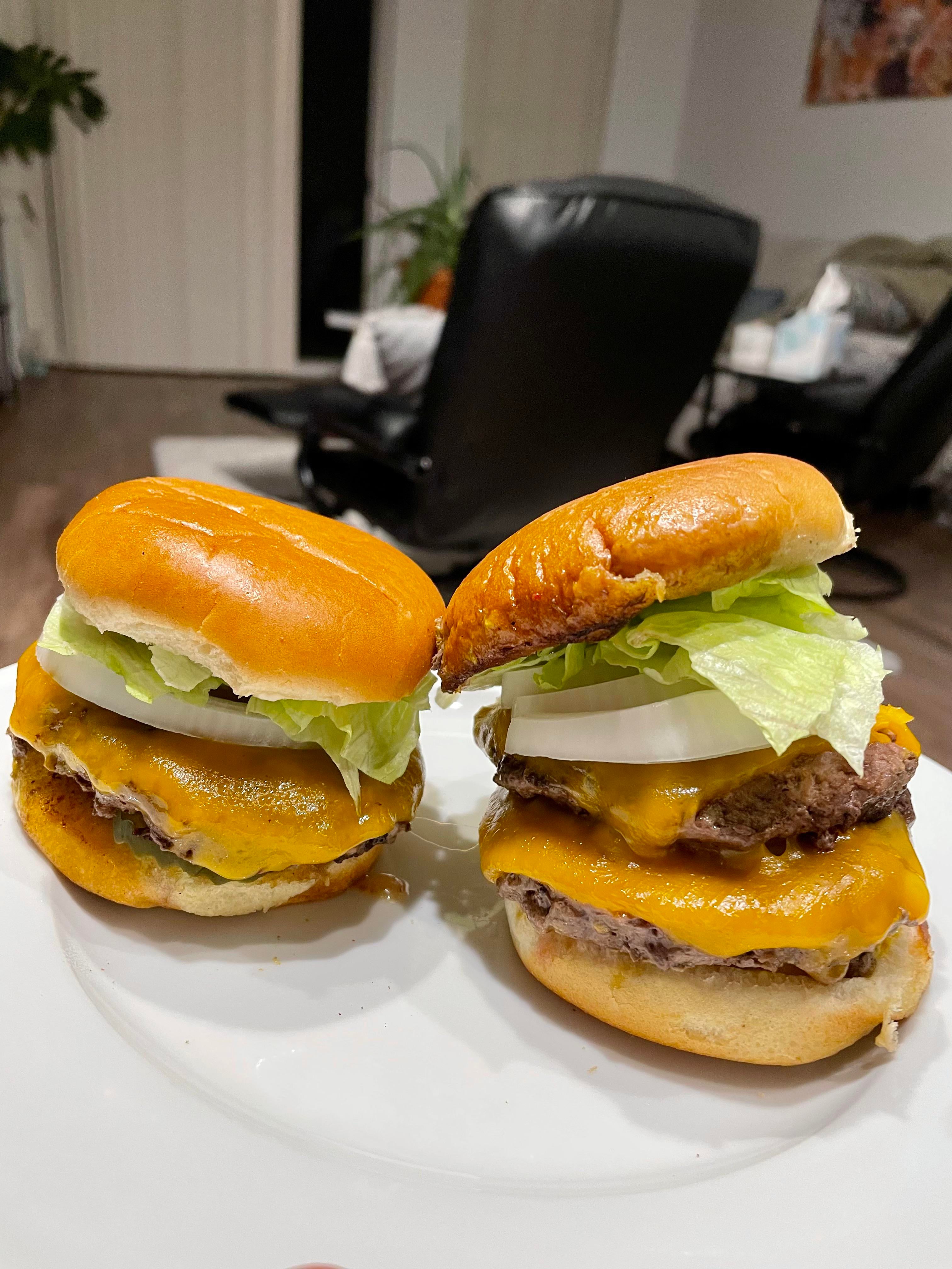 Cheeseburgers. Mustard fried patties on the cast iron, sharp cheddar, pickles, onion, lettuce