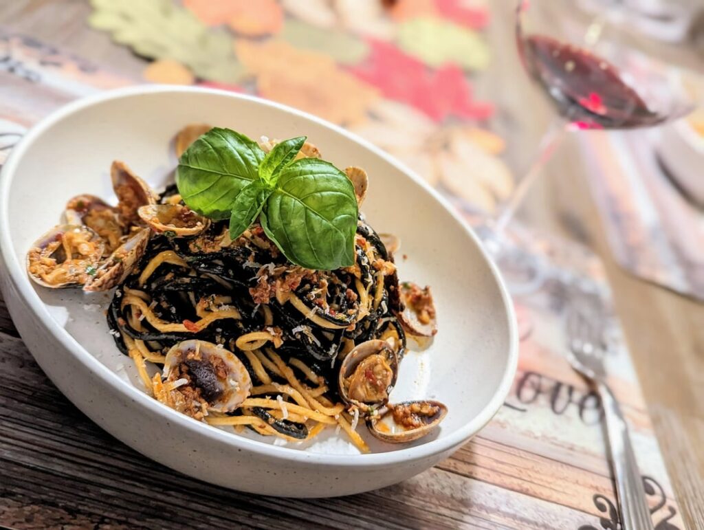 Squid ink pasta with nduja sauce and clam
