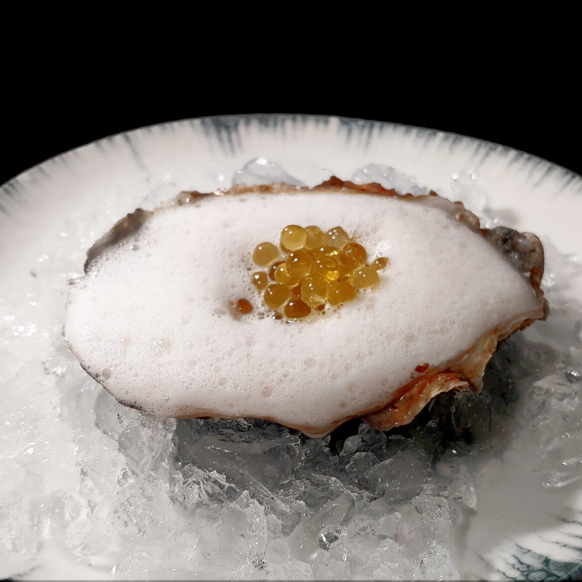 Raw oysters with mignonette foam and lemon caviar.