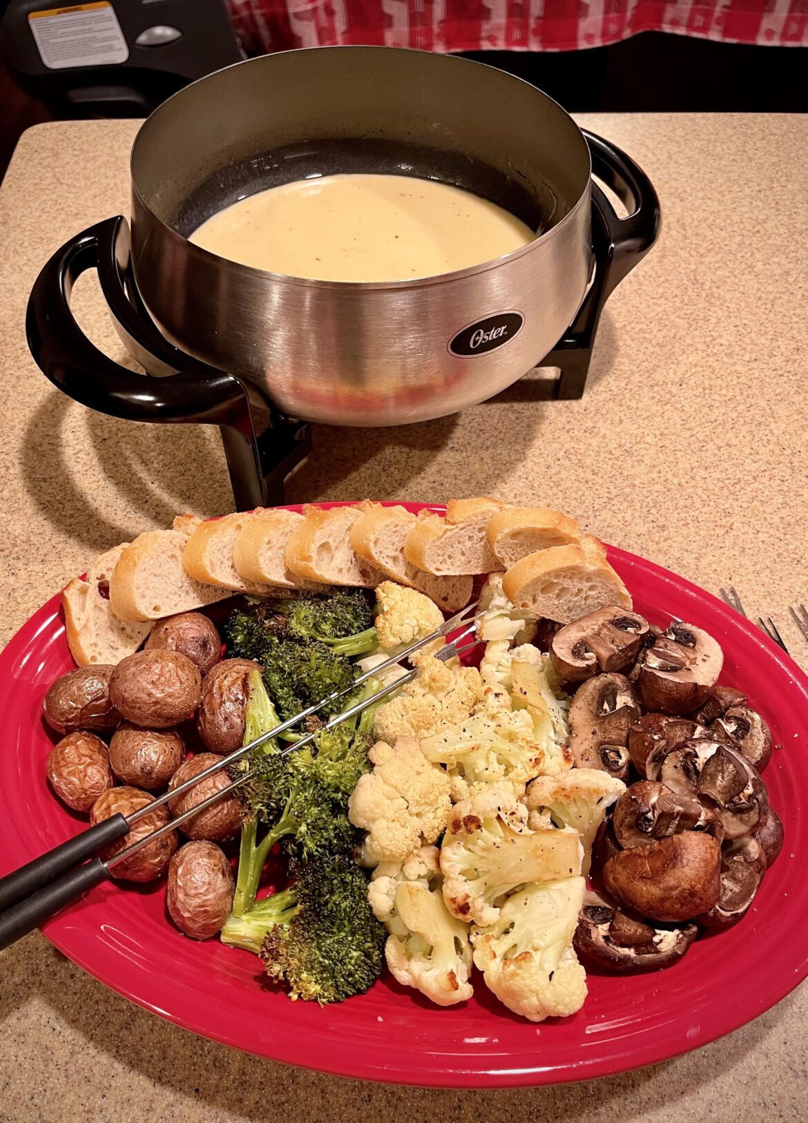 Cheese fondue with roasted baby potatoes, broccoli, cauliflower, mushrooms, and bread.