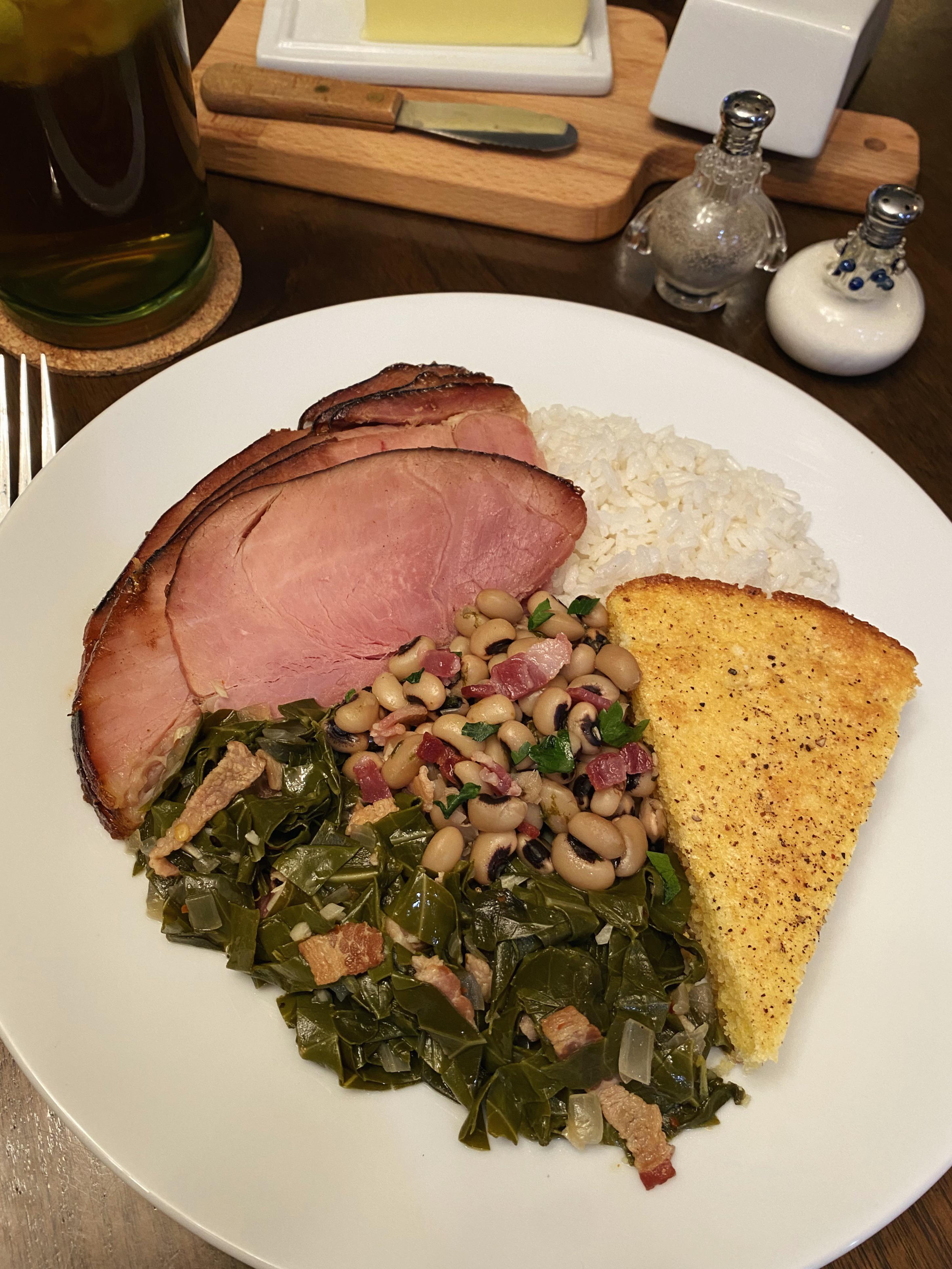 Ham with buttered rice, collard greens, blackeyed peas, and cornbread