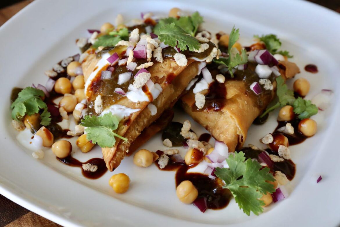 Indian Samosa Chaat with Chickpeas, Puffed Rice, Onion, Cilantro and Spicy Chutney
