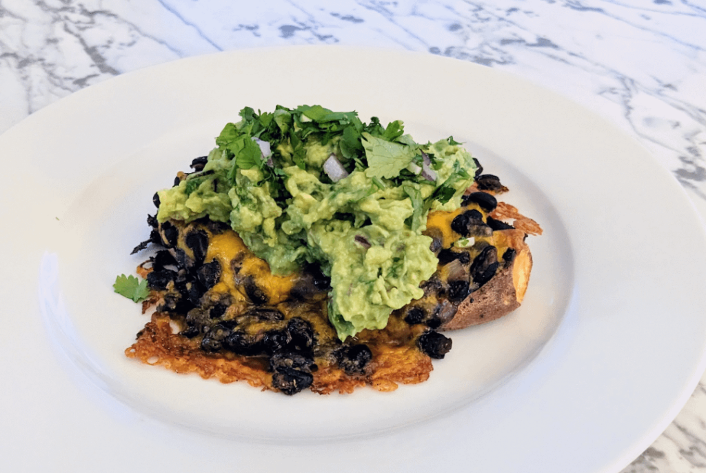 Roasted sweet potatoes with black beans, sharp cheddar, and guacamole