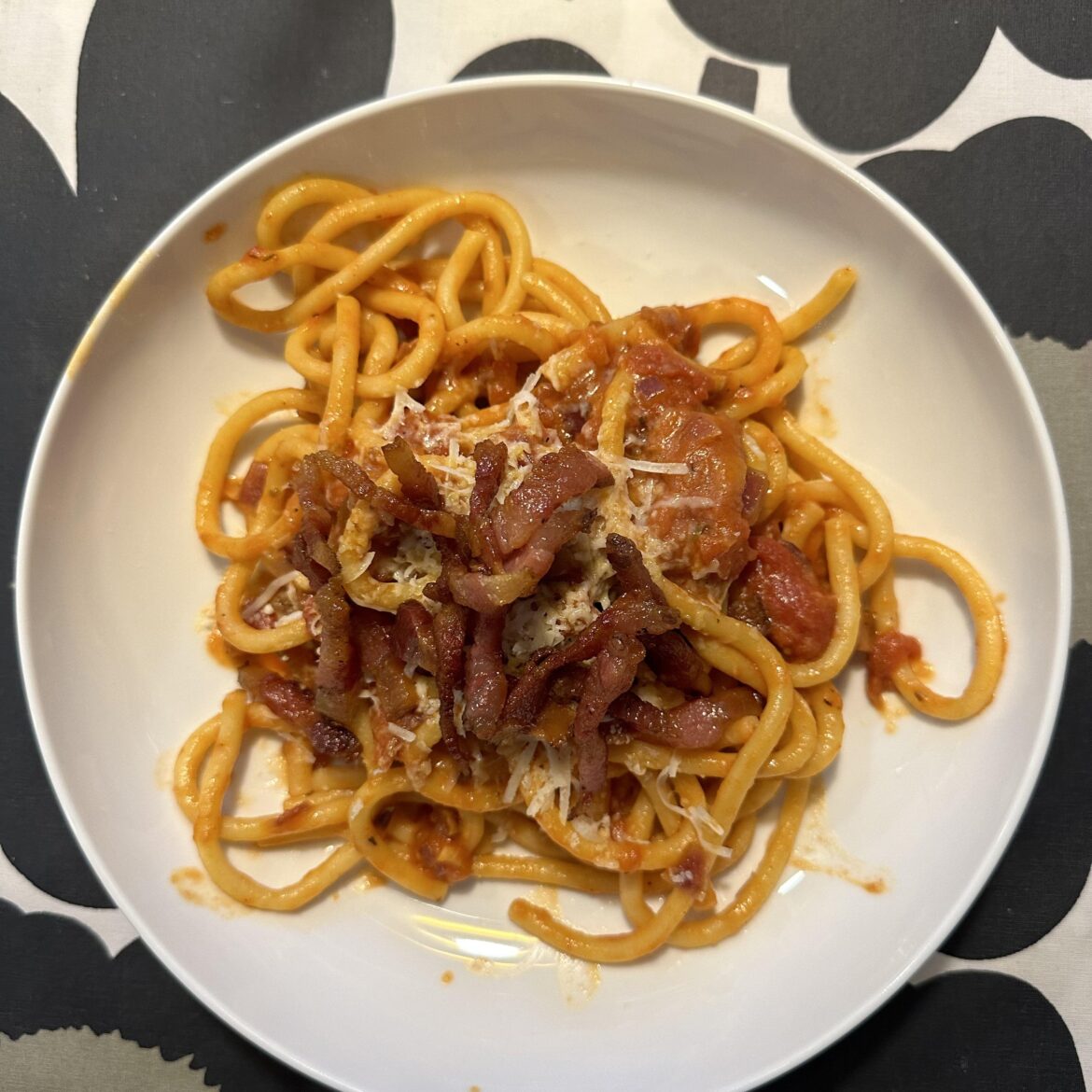Homemade bucatini (extruded) with guanciale, tomato sauce, and pecorino