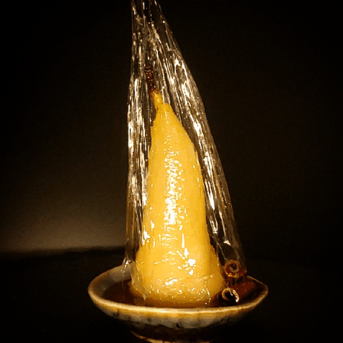 Poached pears with brandy, cinnamon, cloves syrup.