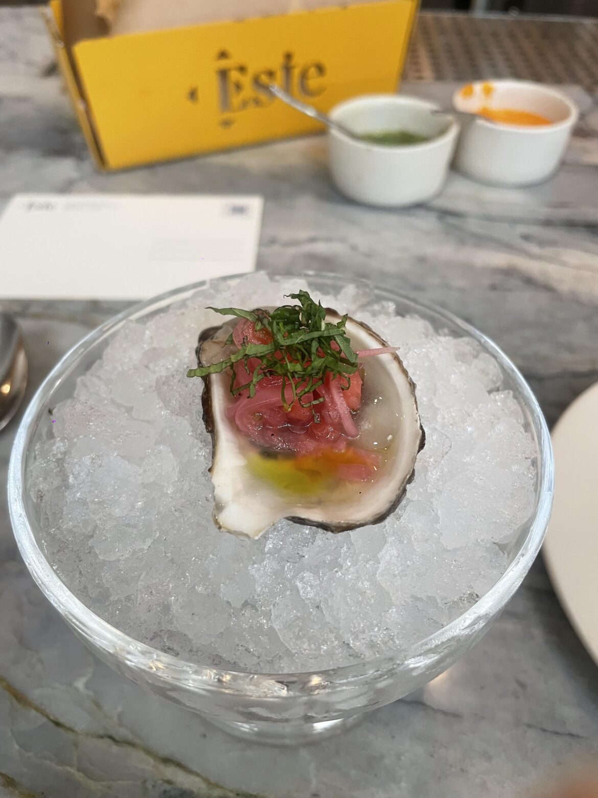 Este - CARIBE OYSTER - ginger-citrus broth, piña y radish slaw, cilantro oil. Incredibly tasty and flavorful, wish they were cheaper than $7 per! Had to try one though, highly recommend!