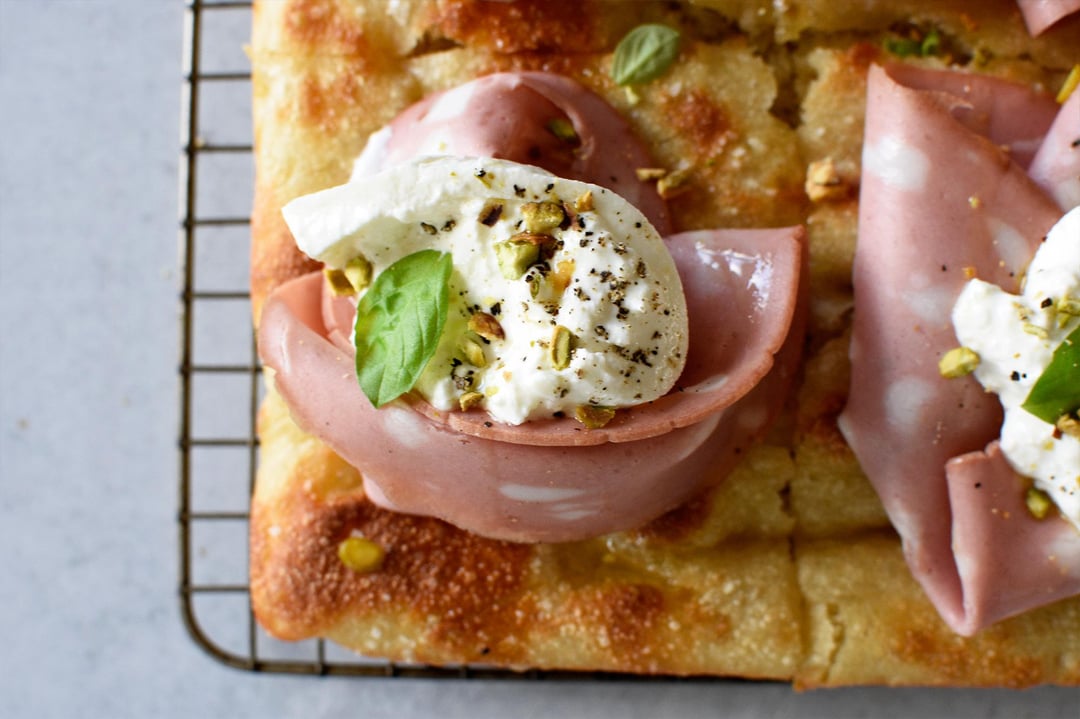 Focaccia with mortadella, burrata, pistachio, basil, EVOO, sea salt