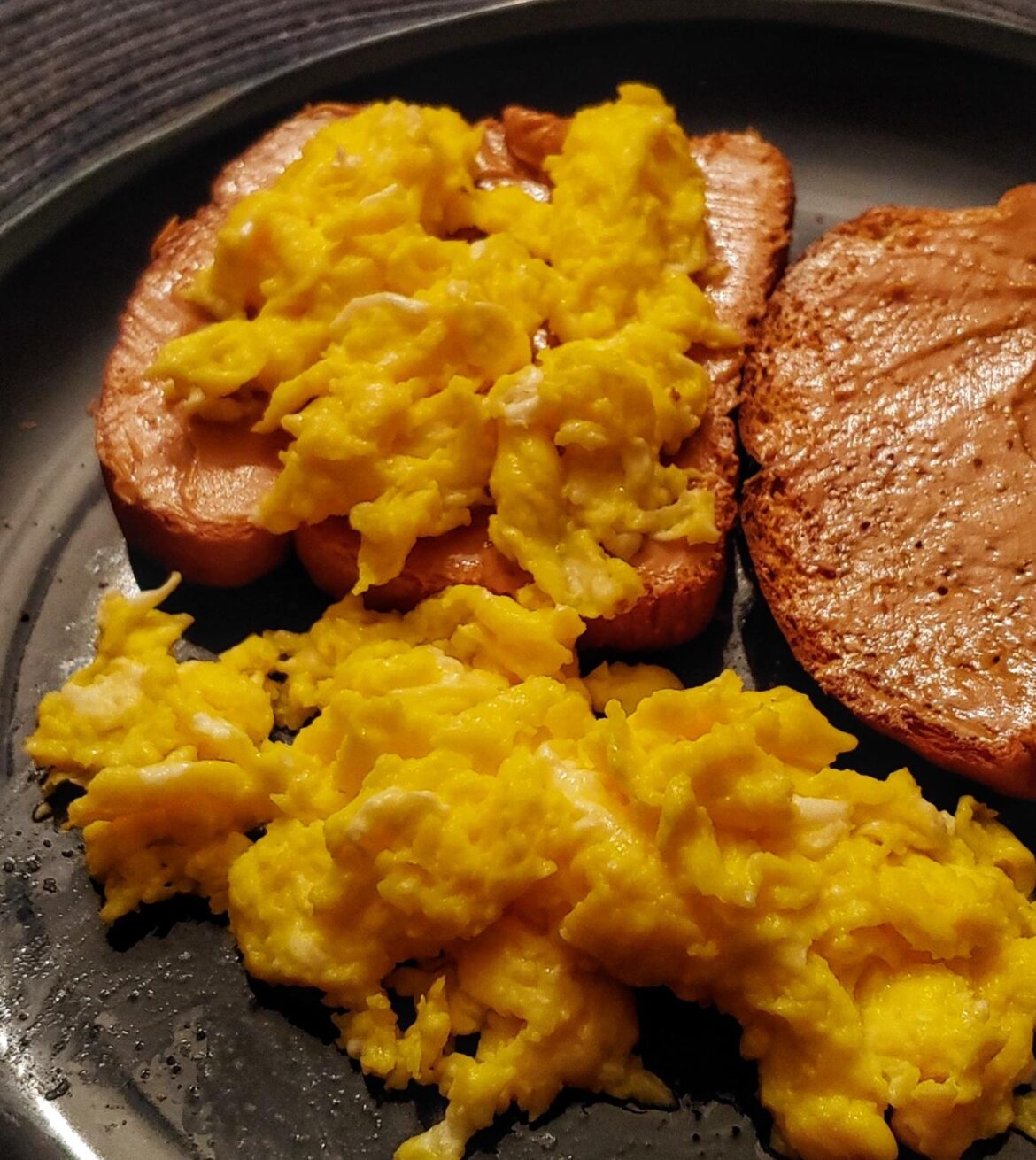 Peanut butter toast with scrambled eggs on top