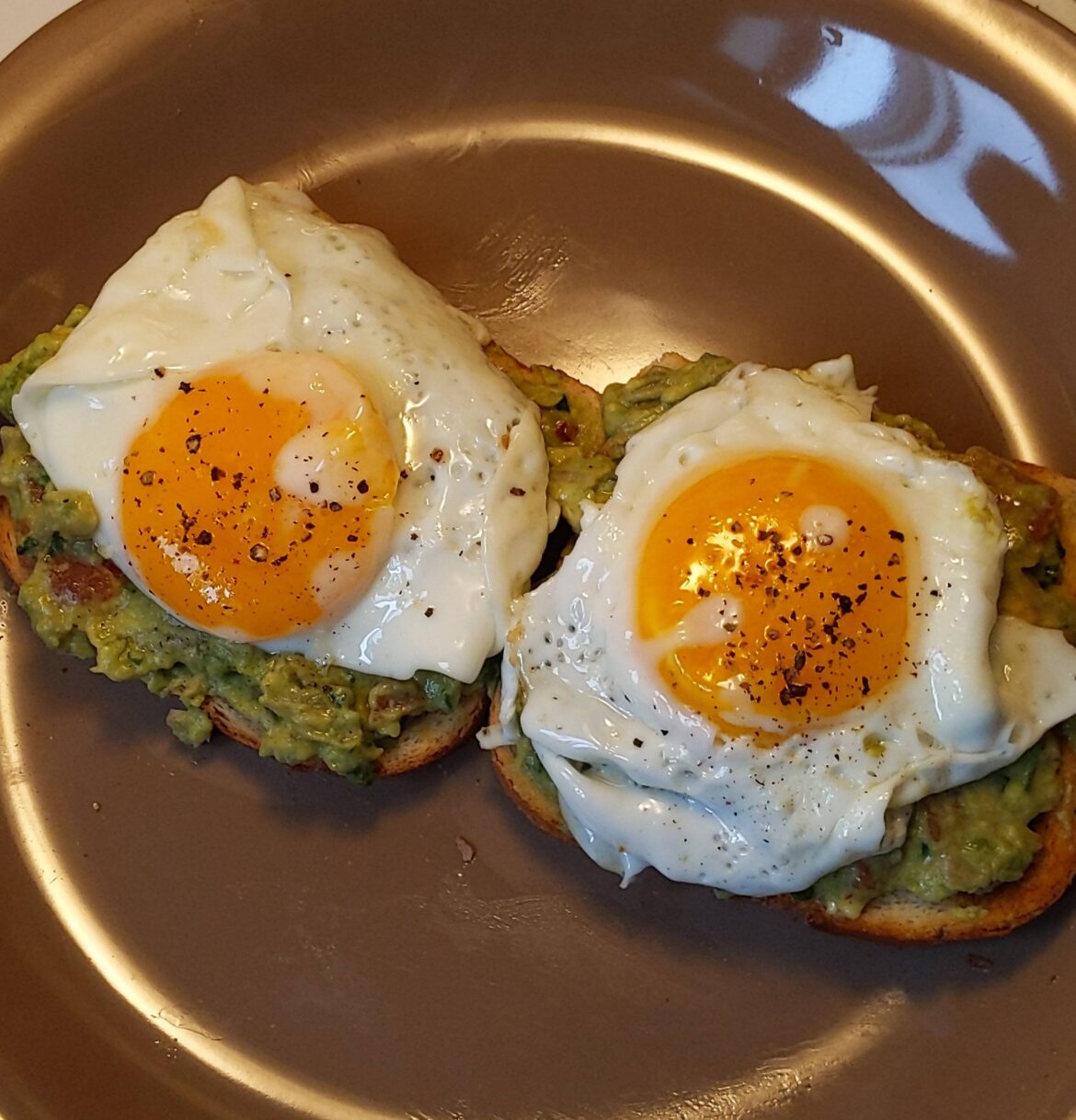 Leftover guac on toast with egg on it