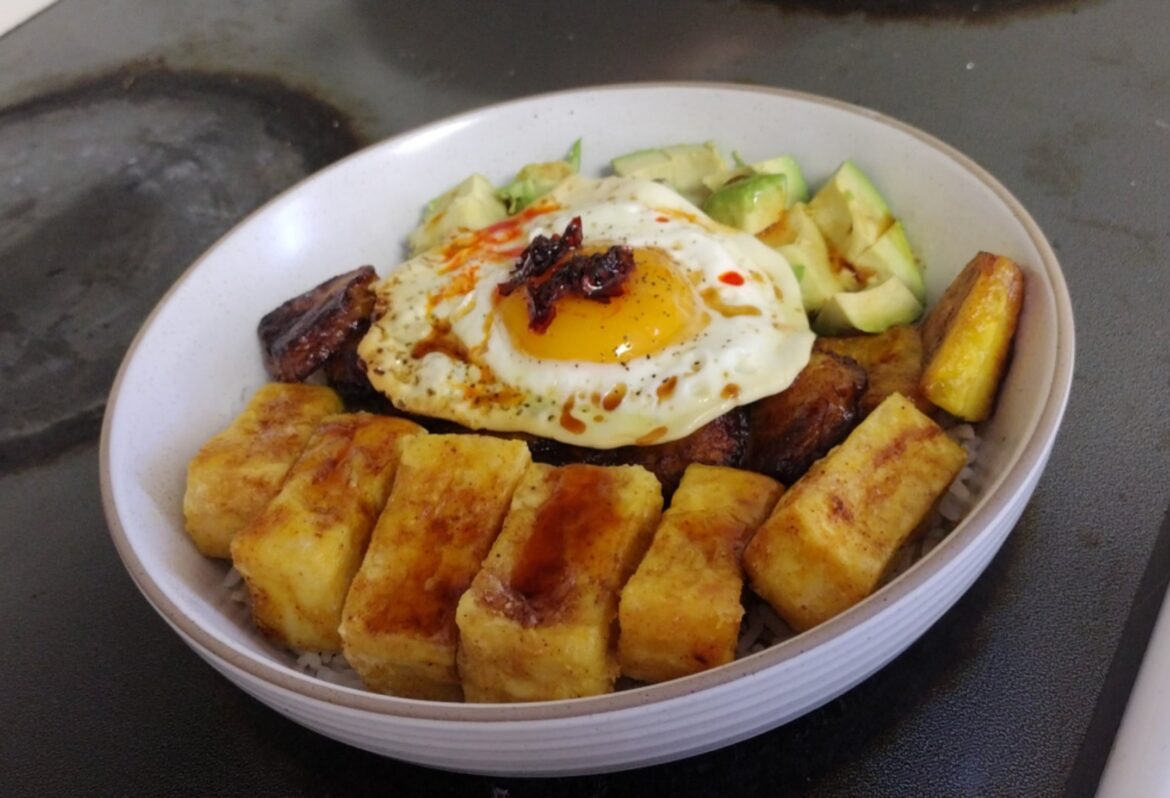 rice bowl with fried tofu, fried plantains, avocado, and topped with egg