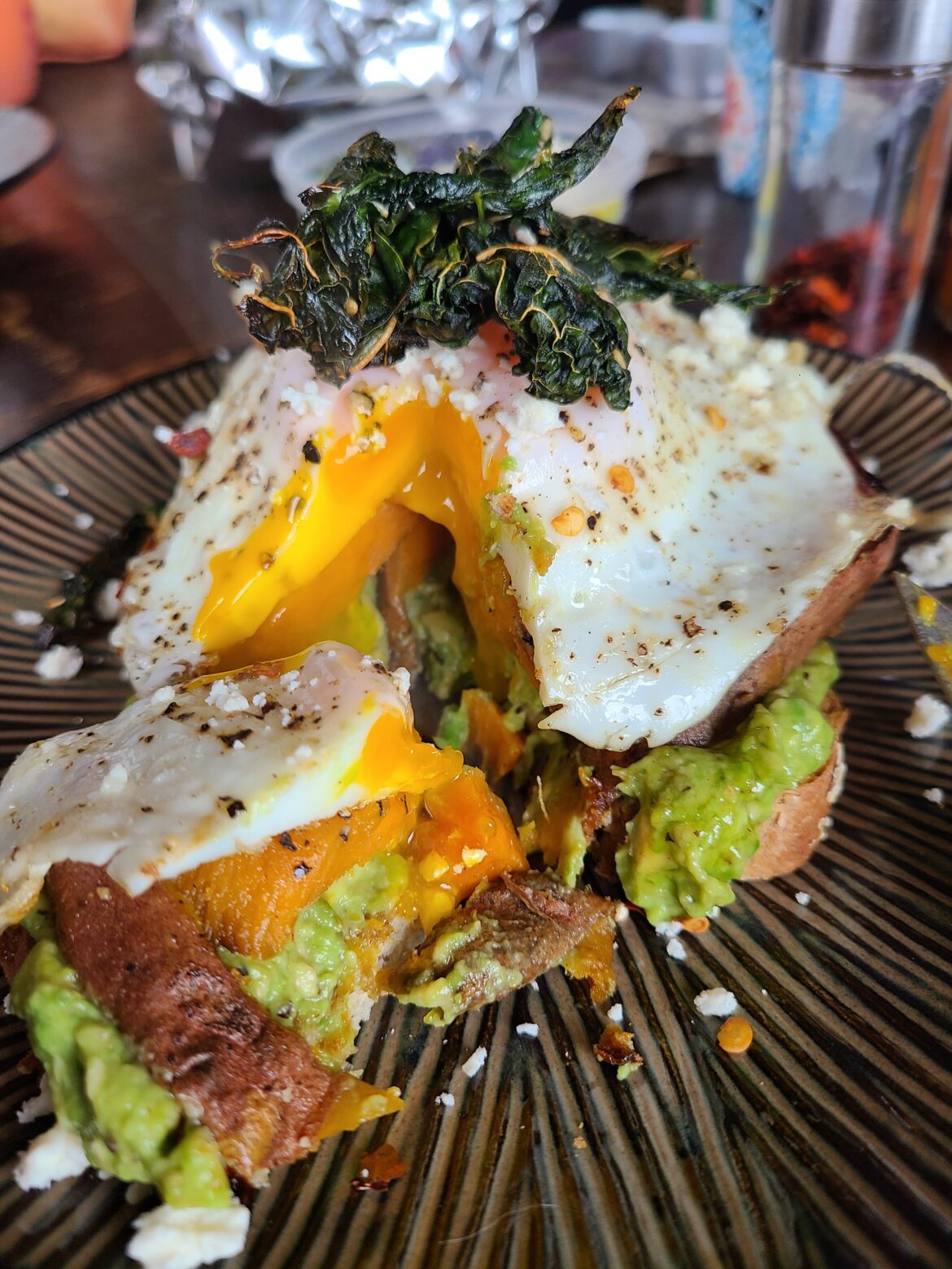 Avocado toast with spicy honey baked sweet potato, fried egg, and crispy kale